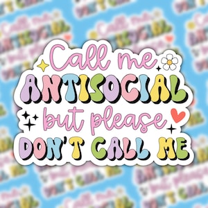May include: A sticker with a colorful, retro-style font that reads "Call me antisocial but please don't call me". The sticker has a white outline and features small decorative elements like stars, a flower, and a heart.