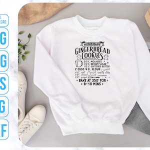 May include: White sweatshirt with black text that reads "HOMEMADE GINGERBREAD COOKIES" and includes a recipe for gingerbread cookies. The recipe includes ingredients such as molasses, brown sugar, softened butter, eggs, flour, salt, cloves, baking soda, ginger, and cinnamon. The recipe also includes instructions to bake at 350 degrees Fahrenheit for 8-10 minutes.