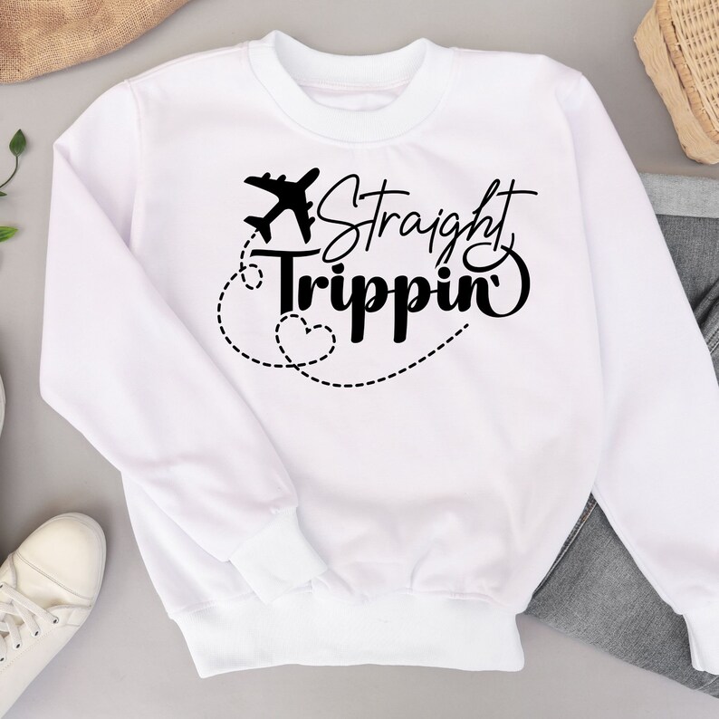 Może przedstawiać: Biała bluza z czarnym napisem "Straight Trippin'" i małym nadrukiem samolotu.