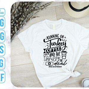 K&ouml;nnte beinhalten: Wei&szlig;es T-Shirt mit schwarzem Text, der "Running on Turkey Coffee and the thrill of the deal #BlackFriday" lautet.