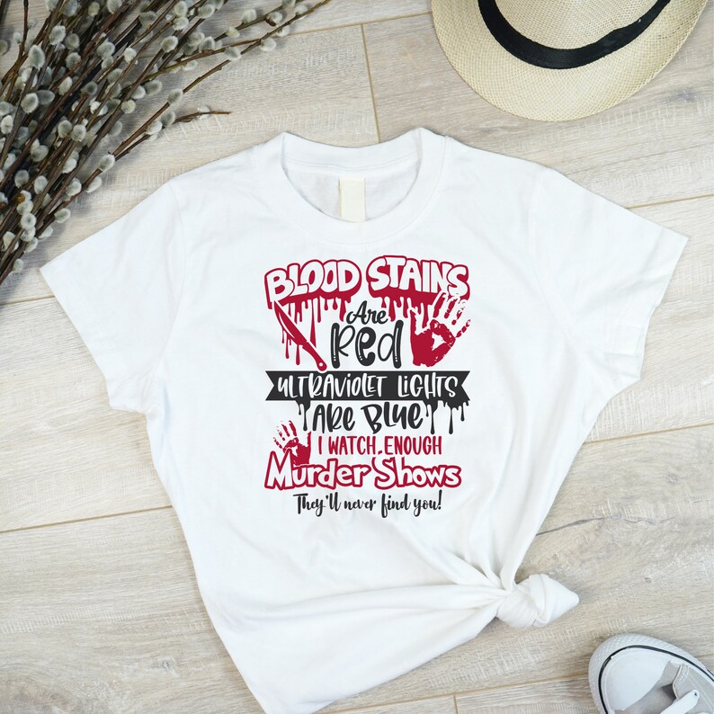 May include: White t-shirt with a red graphic that says "Blood Stains Are Red Ultraviolet Lights Are Blue I Watch Enough Murder Shows They'll Never Find You!"