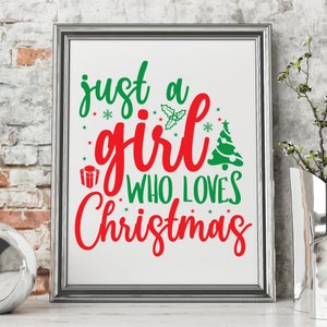 Pu&ograve; includere: Una stampa incorniciata con il testo "just a girl who loves Christmas" in lettere rosse e verdi. Il testo &egrave; circondato da piccole stelle e fiocchi di neve.