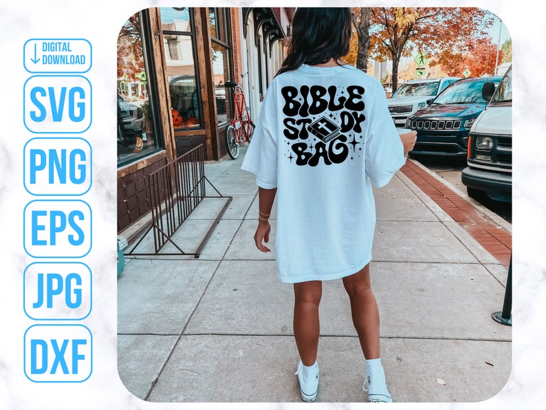 Op de afbeelding: Wit T-shirt met een zwarte afbeelding met de tekst "Bible Study Bag" met een cartoon afbeelding van een gesloten boek met een kruis erop.