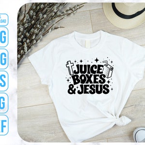 May include: White t-shirt with a black graphic design that says "Juice Boxes & Jesus" with a cross and a juice box.