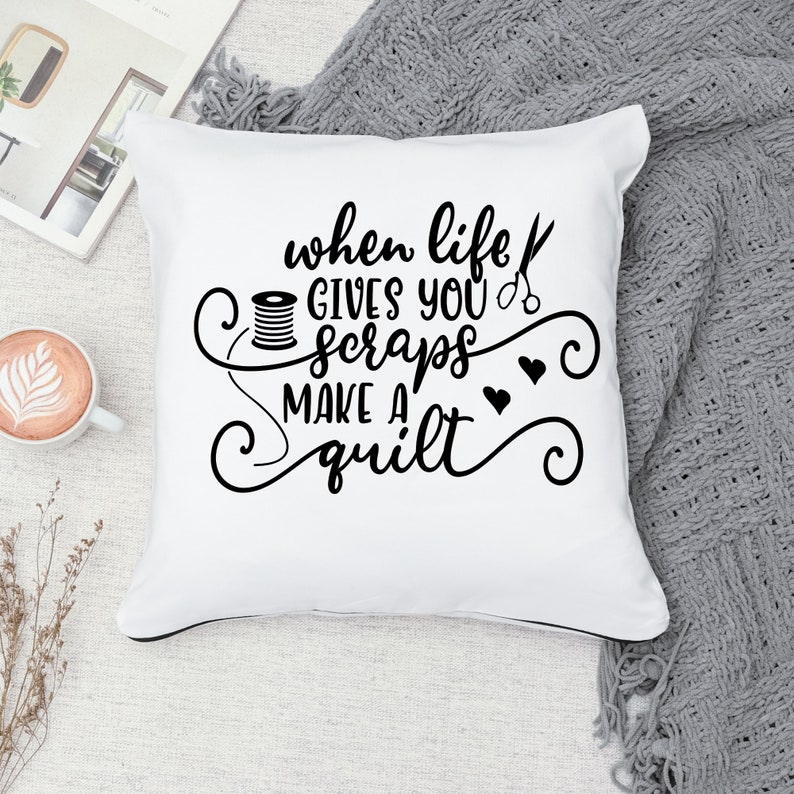 May include: White throw pillow with black text that reads "When life gives you scraps make a quilt". The text is surrounded by decorative swirls and hearts.