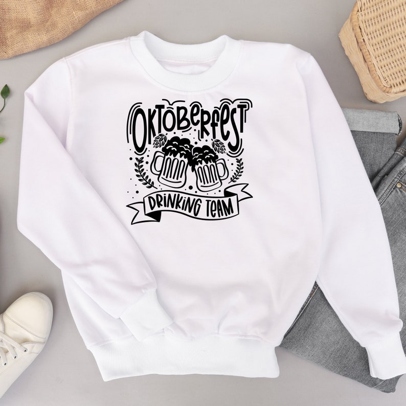 May include: White sweatshirt with black text that reads "Oktoberfest Drinking Team" with a graphic of two beer steins.