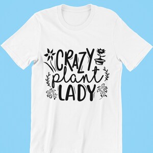 May include: White t-shirt with black text that reads "Crazy Plant Lady" with a flower and potted plant graphic.