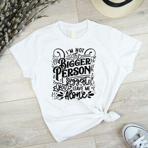 May include: White t-shirt with black text that reads "I'm not the bigger person - I suggest you leave me alone".