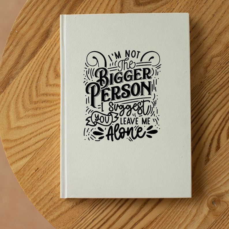 May include: A white notebook with black lettering that reads "I'm not the bigger person I suggest you leave me alone".