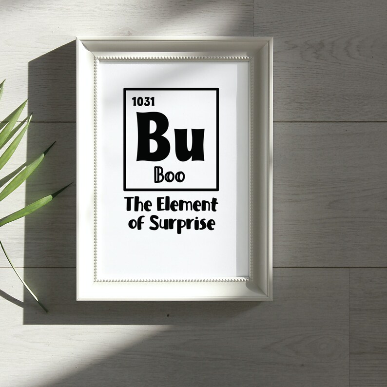 K&ouml;nnte beinhalten: Ein wei&szlig;er gerahmter Druck mit schwarzem Text, der "1031 Bu Boo The Element of Surprise" lautet. Der Text ist so gestaltet, dass er wie ein Element des Periodensystems aussieht.