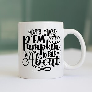 May include: White ceramic coffee mug with black text that reads "Let's give 'em pumpkin to talk about". A small pumpkin graphic is included in the text.