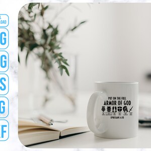 Puede incluir: Taza de cer&aacute;mica blanca con un dise&ntilde;o negro que dice "Ponte la armadura completa de Dios" con un gr&aacute;fico de la armadura de Dios y la referencia b&iacute;blica "Efesios 6:10".