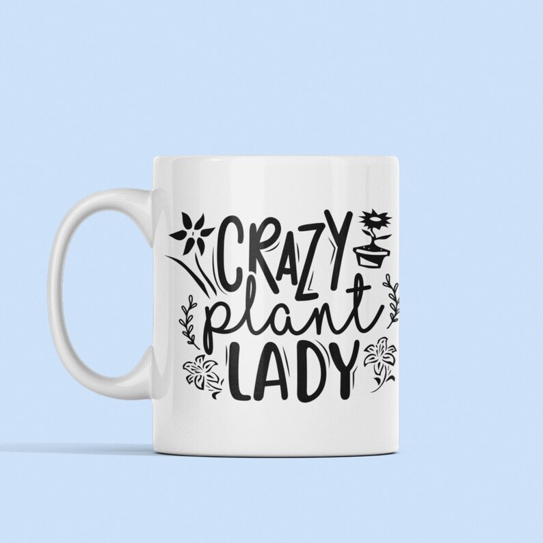 May include: White ceramic mug with a black design that says "Crazy Plant Lady" with stylized flowers and a potted plant.