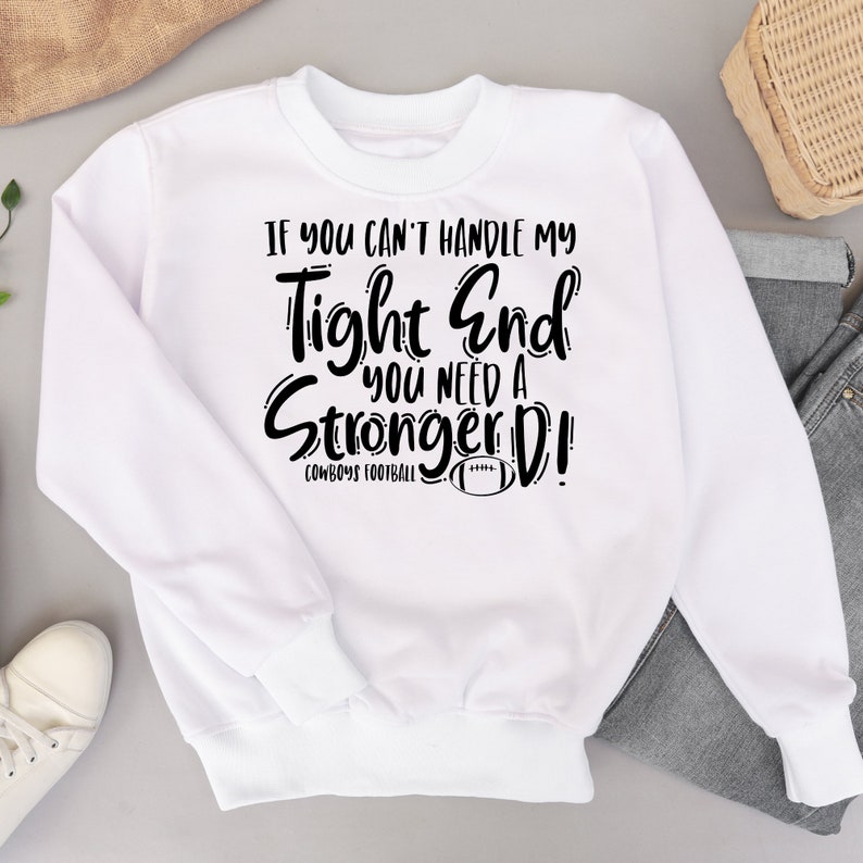 May include: White sweatshirt with black text that reads "If you can't handle my tight end you need a stronger D!" with a football graphic and the words "Cowboys Football" below the text.
