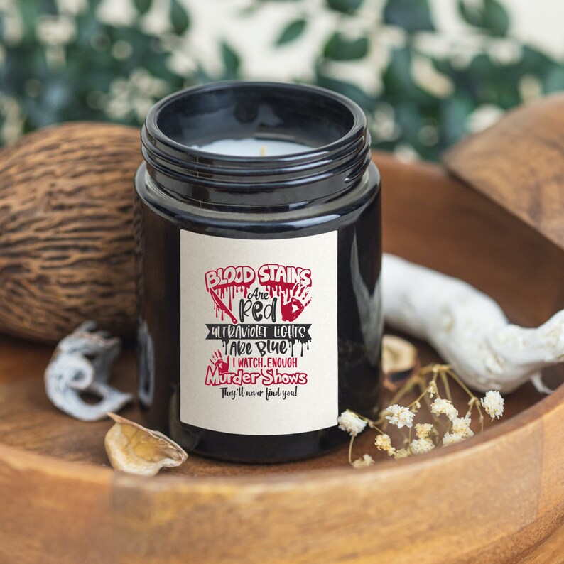 May include: Black candle jar with a white label that reads "Blood Stains Are Red Ultraviolet Lights Take Blue I Watch Enough Murder Shows They'll Never Find You!"