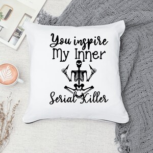 May include: White throw pillow with black text that reads "You inspire my inner serial killer" and a black skeleton illustration in a yoga pose.