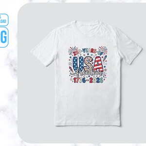 May include: White t-shirt featuring a patriotic design celebrating 250 years of USA freedom. The graphic includes the text "250 Years of USA freedom 1776-2026" in red, white, and blue, with stars, fireworks, and a leopard print pattern.