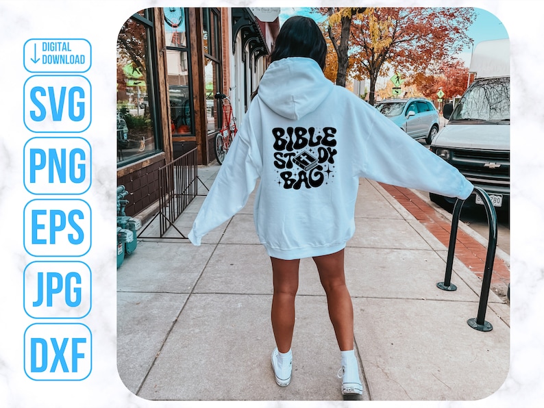 Op de afbeelding: Een witte hoodie met de tekst "Bible Study Bag" in zwarte letters op de rug. De tekst is in een retro, golvend lettertype.