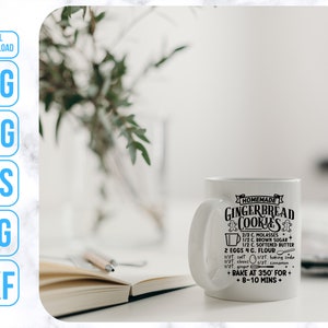 May include: White ceramic mug with a black design that reads "Homemade Gingerbread Cookies" and includes a recipe for gingerbread cookies. The mug is sitting on a white marble surface.