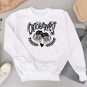 May include: White sweatshirt with black text that says "Oktoberfest" and a graphic of two beer steins clinking together with a heart in between.