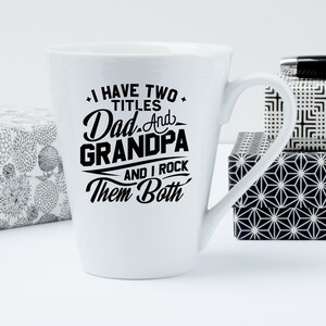 May include: White ceramic coffee mug with a black design that reads "I have two titles Dad and Grandpa and I rock them both".