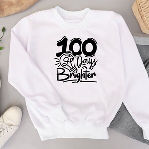 May include: White sweatshirt with black text that reads "100 Days Brighter" with a lightbulb graphic.