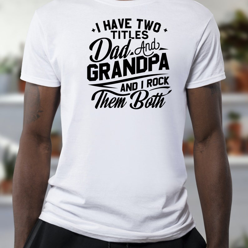 May include: White t-shirt with black text that reads "I have two titles Dad and Grandpa and I rock them both."