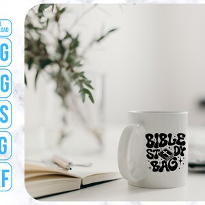 Op de afbeelding: Een witte keramische mok met een zwart ontwerp met de tekst "Bible Study Bag" en een klein afbeelding van een gesloten boek.