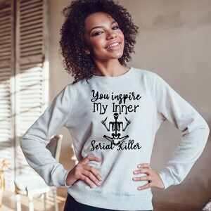 May include: A gray sweatshirt with the text "You inspire my inner Serial Killer" and a black skeleton illustration in a yoga pose.