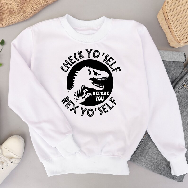 May include: White sweatshirt with a black graphic of a dinosaur with the text "Check Yo'self Before Rex Yo'self"