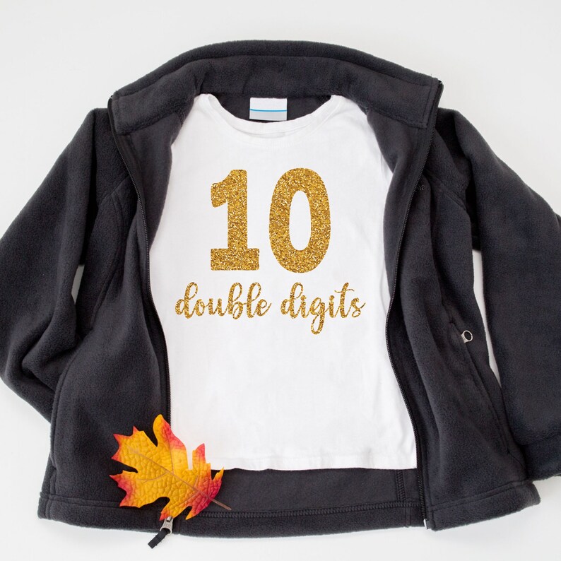 May include: White t-shirt with gold glitter number 10 and the text "double digits".