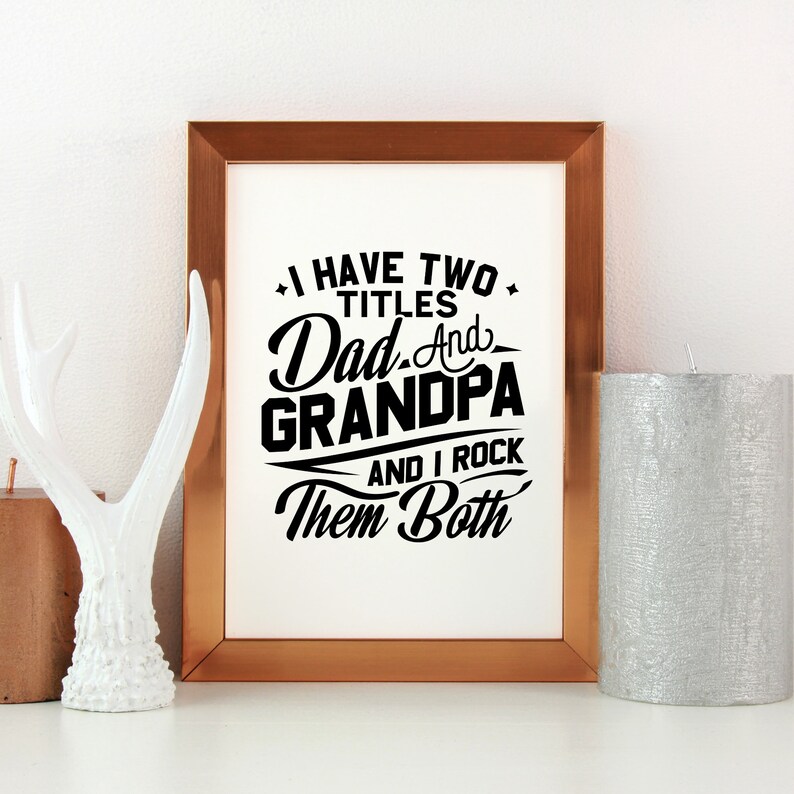May include: A framed print with a black and white design that says "I have two titles Dad and Grandpa and I rock them both". The frame is copper colored.
