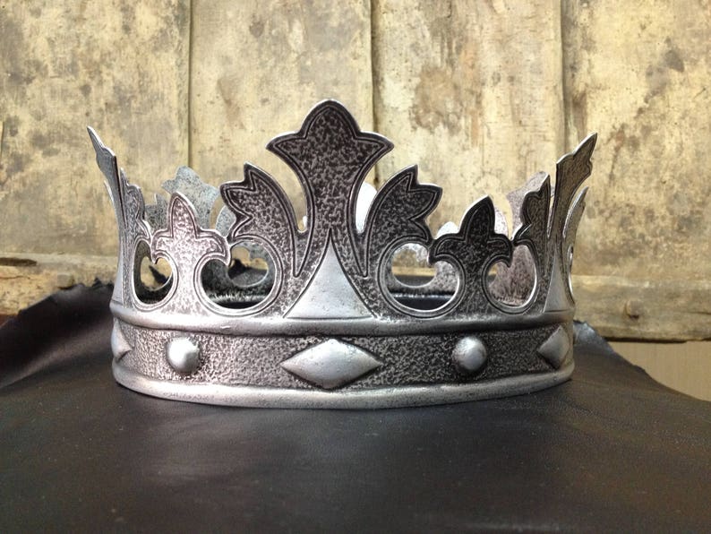Peut inclure: Une couronne en argent avec une surface textur&eacute;e et des d&eacute;tails complexes. La couronne a un sommet pointu et une bande avec des accents d&eacute;coratifs.
