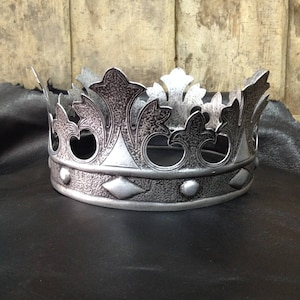 Peut inclure: Une couronne argent&eacute;e avec une surface textur&eacute;e et un design d&eacute;coratif. La couronne a une bande avec des accents en forme de diamant et des embellissements ronds.