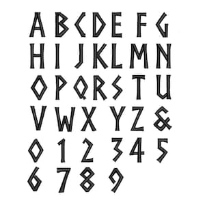 Könnte beinhalten: Schwarz gestickte Buchstaben, Zahlen und ein kaufmännisches Und-Zeichen auf weißem Hintergrund. Die Buchstaben sind in einer stilisierten Schriftart gehalten, wobei einige Buchstaben eine rautenförmige Form haben. Die Zahlen 0-9 sind ebenfalls enthalten.