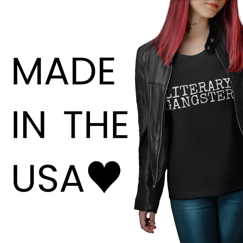A person with red hair wearing a black leather jacket and a black t-shirt with the text "MADE IN THE USA" and a heart symbol.