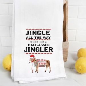 May include: White kitchen towel with a red and black graphic of a donkey wearing a Santa hat and a red and white sweater. The text reads "Jingle All The Way Nobody Likes A Half-Assed Jingler".