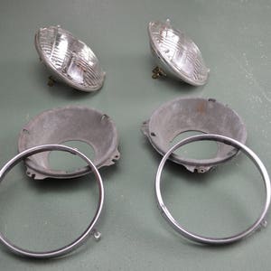 May include: Two silver headlight bezels with chrome trim and two clear glass headlights.