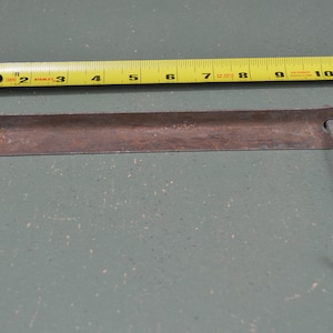 May include: A rusty metal bracket with two hooks. The bracket is approximately 8 inches long.