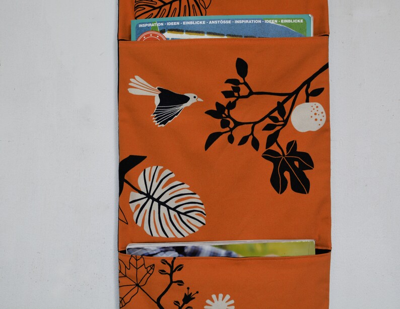 Wall utensil for magazines Mrs Knallerbse The orange wall organizer with birds and branches creates storage space in the office image 3