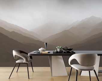 May include: A dining room set featuring a dark rectangular table with a white geometric base and two white curved chairs. The table holds a white vase, a tall black glass, a small succulent, and a black bowl. The wall displays a mountain mural.