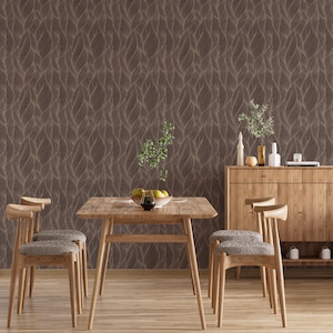 May include: A dining room scene featuring a wooden table and chairs, a wooden cabinet, and a brown leaf-patterned wallpaper. The table is set with a bowl of fruit and a glass of wine. The chairs have gray upholstered seats.