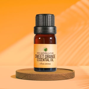 May include: A small amber glass bottle with a black cap, containing sweet orange essential oil. The bottle is labeled "100% Natural & Pure Sweet Orange Essential Oil citrus sinensis".