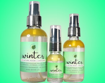 May include: Three glass bottles of room and linen spray with a winter scent. The bottles are labeled "winter" and list the ingredients as distilled Madagascar vanilla, pepper, cinnamon, cypress, nutmeg, and orange. The bottles are clear and have a textured surface. The bottles are in different sizes.