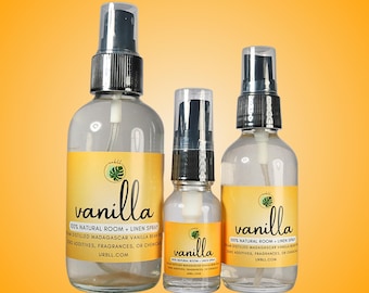 May include: Three glass bottles with spray tops filled with clear liquid. The bottles have labels with the word "vanilla" and the text "100% Natural Room + Linen Spray" in black text on a yellow background.