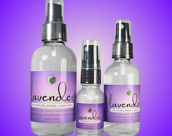 May include: Three glass bottles of lavender room and linen spray. The bottles are clear and have a white label with the word "lavender" in purple text. The bottles are in different sizes, with the largest bottle being in the center.