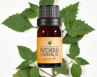 May include: A small amber glass bottle of patchouli essential oil with a black cap, set against a backdrop of fresh green leaves. The label reads "100% Natural & Pure Patchouli Essential Oil". The product is likely used for aromatherapy.
