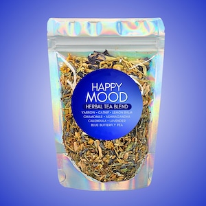 May include: A clear, iridescent pouch filled with a herbal tea blend. A blue circular label reads "HAPPY MOOD HERBAL TEA BLEND" with a list of ingredients: yarrow, catnip, lemon balm, chamomile, ashwagandha, calendula, lavender, and blue butterfly pea.