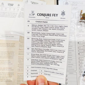 May include: A close-up of a white card with black text listing various creatures and their corresponding challenge rating (CR) for a Dungeons and Dragons game. The card is titled "Conjure Fey" and is a 6th level Warlock spell.
