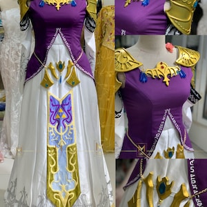 May include: A white and purple dress with gold accents and a blue and gold design. The dress has a long skirt and a fitted bodice. The dress is decorated with a gold chain and a gold pendant.